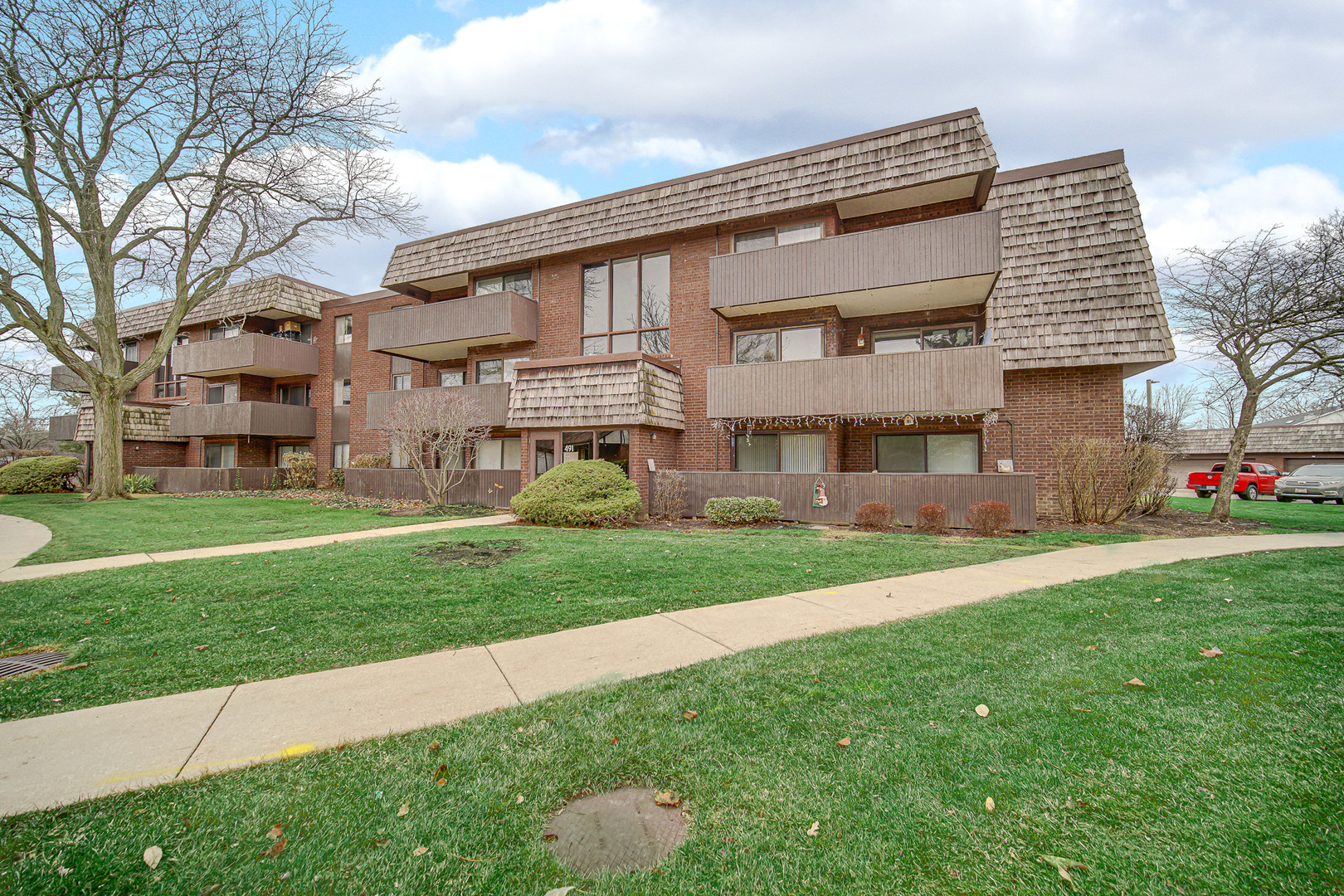 491 Timber Ridge Drive, Unit 101 Carol Stream, IL 60188 - Photo 3 of 19 a front view of a house with a garden and plants