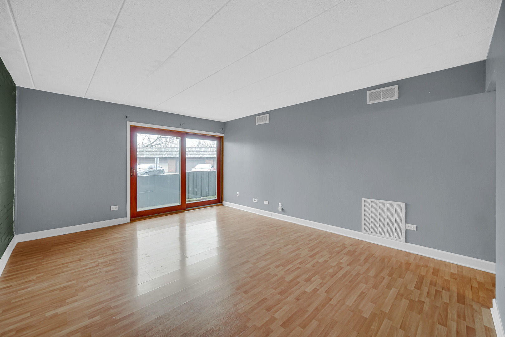 491 Timber Ridge Drive, Unit 101 Carol Stream, IL 60188 - Photo 7 of 19 a view of an empty room with wooden floor and a window
