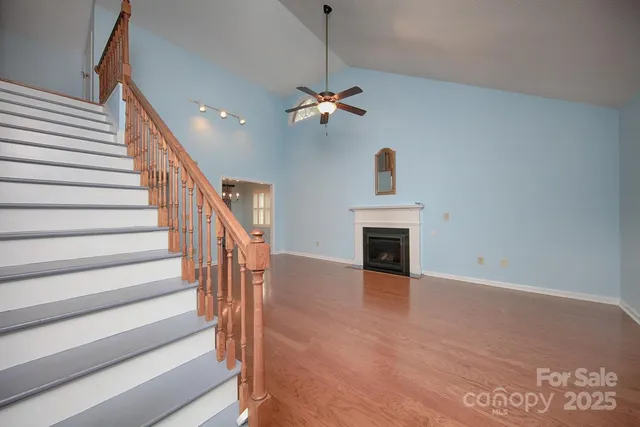 a view of a livingroom with wooden floor and a ceiling fan
