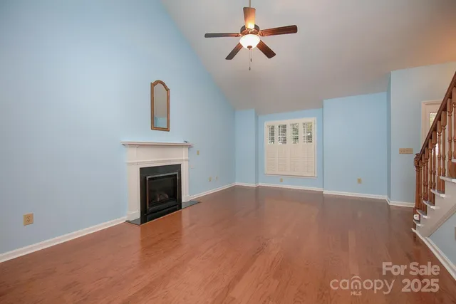 a view of empty room with wooden floor and fireplace