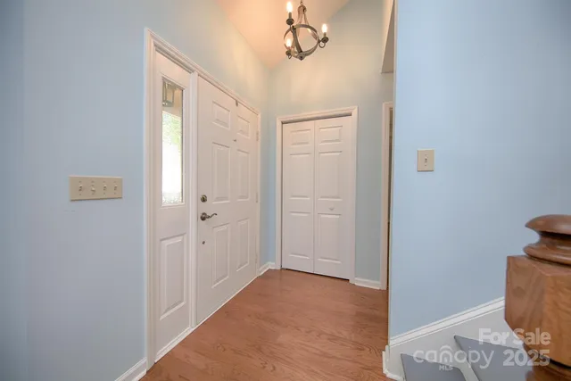 a view of a hallway with closet and wooden floor