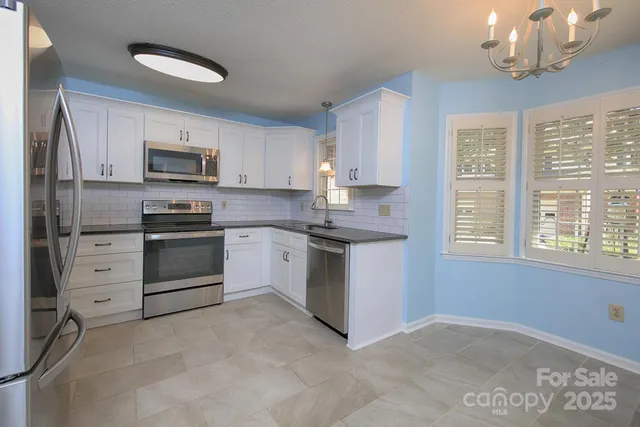 a kitchen with stainless steel appliances a white stove top oven a sink and dishwasher