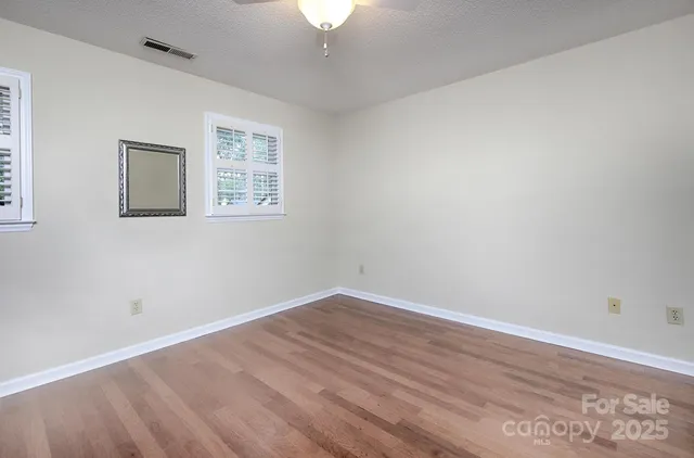 a view of a room with wooden floor and a chandelier