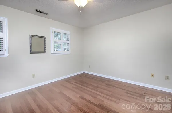 a view of a room with wooden floor and a chandelier