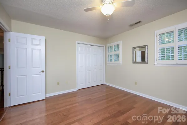 a view of a room that has wooden floor and windows in it