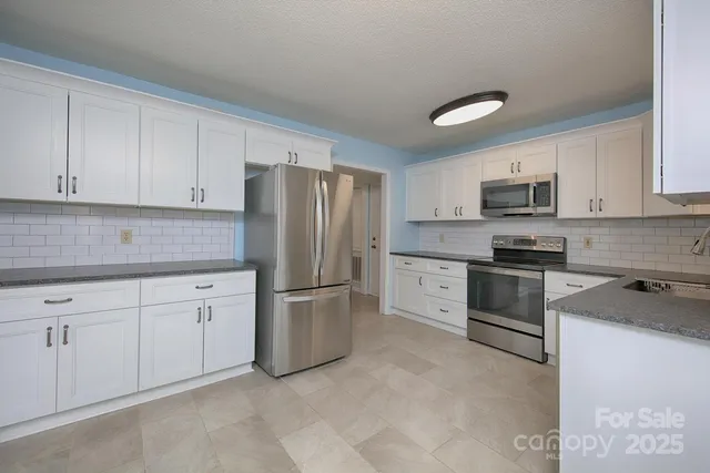a kitchen with cabinets stainless steel appliances and a sink