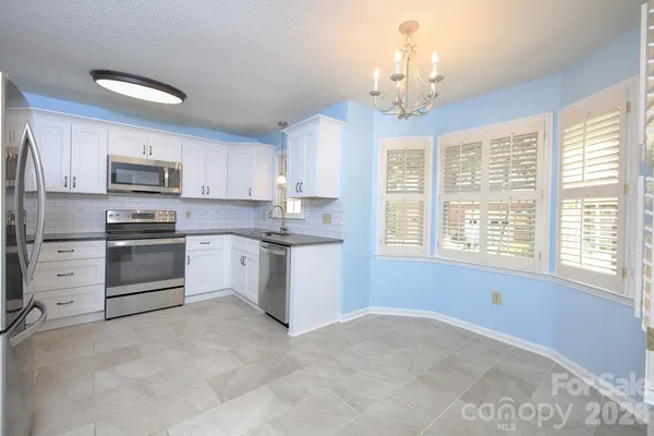 a kitchen with stainless steel appliances a stove a sink dishwasher a refrigerator and a microwave