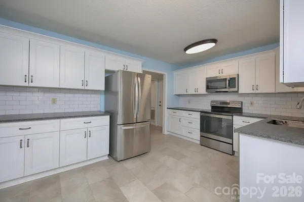 a kitchen with cabinets stainless steel appliances and a sink