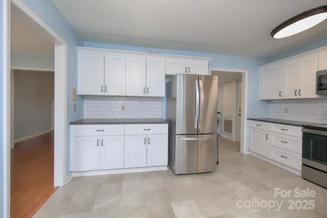 a kitchen with stainless steel appliances granite countertop a refrigerator sink and cabinets