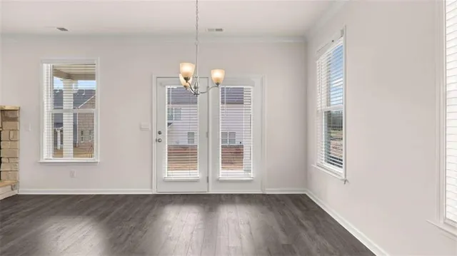 a view of an empty room with wooden floor and a fireplace