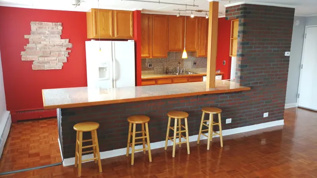 a kitchen with a table chairs and a wooden floor