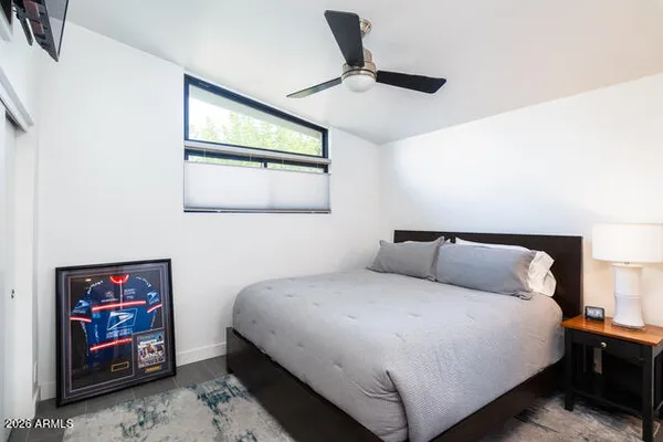a bedroom with a bed and a painting on the wall
