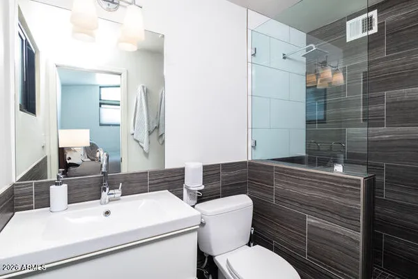 a bathroom with a sink mirror and toilet