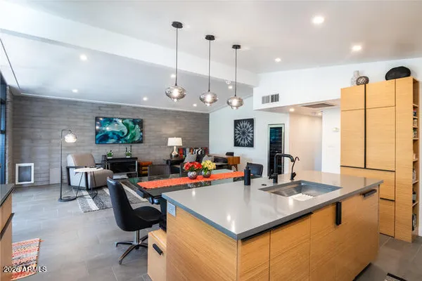 a view of a kitchen with kitchen island stainless steel appliances a dining table and chairs