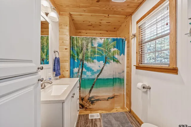 a bathroom with a sink and mirror with bathtub