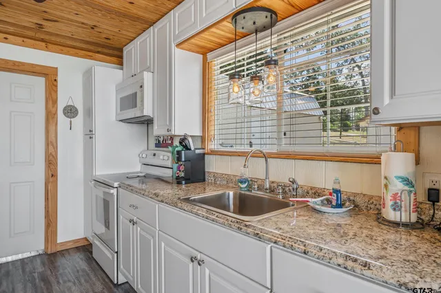 a kitchen with stainless steel appliances granite countertop a sink and a wooden cabinets