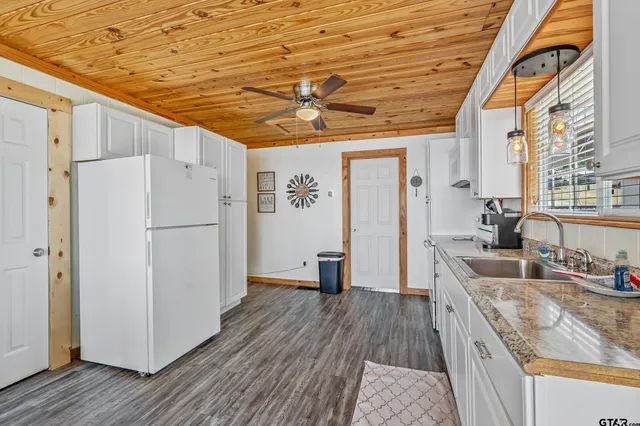 a kitchen with granite countertop a refrigerator and a sink