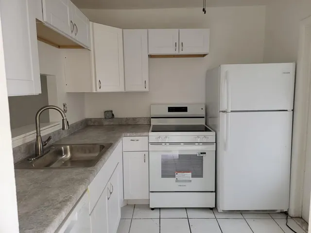 a kitchen with appliances a sink and cabinets