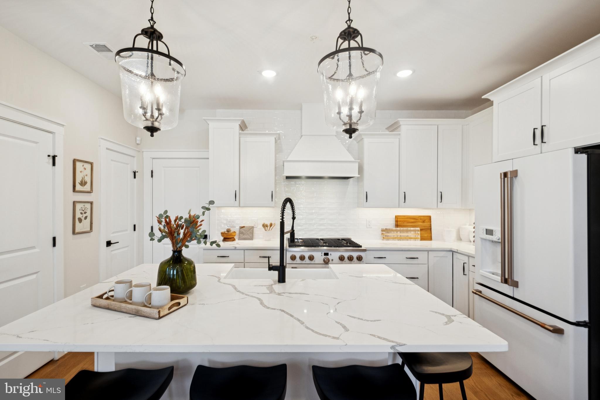 14960 Deco Circle Chantilly, VA 20151 - Photo 10 of 35 a kitchen with kitchen island a stove a chandelier and a dining table