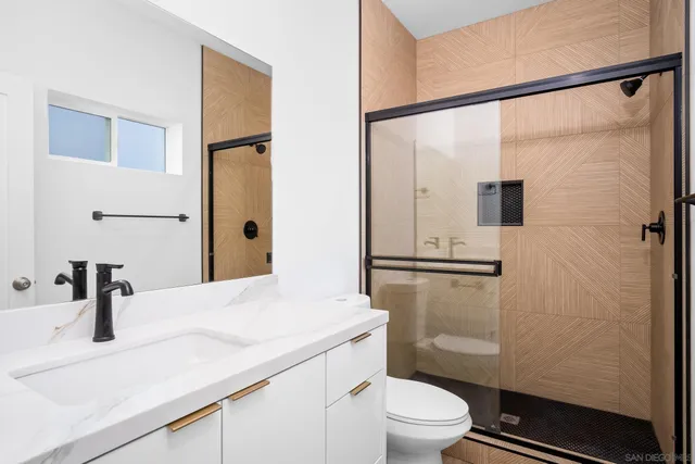 a bathroom with a granite countertop sink toilet and shower