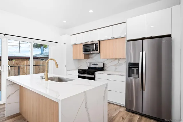 a kitchen with a refrigerator sink and cabinets