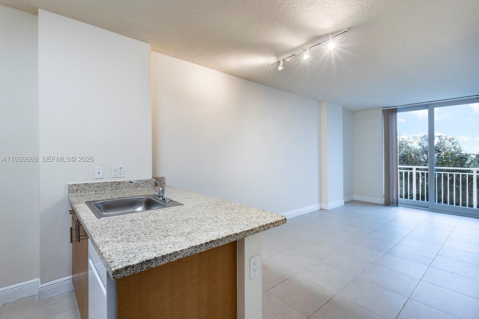 2350 Southwest 27th Avenue, Unit 809 Miami, FL 33145 - Photo 2 of 21 a kitchen with a sink and a mirror
