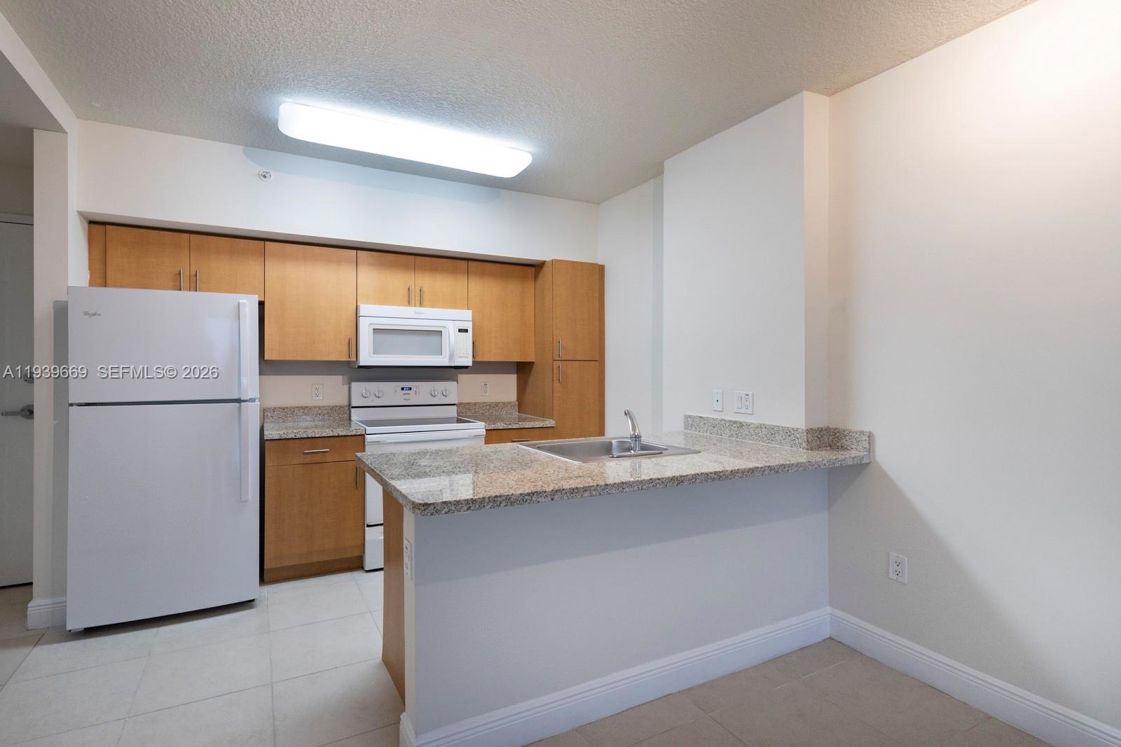 2350 Southwest 27th Avenue, Unit 809 Miami, FL 33145 - Photo 5 of 21 a kitchen with stainless steel appliances granite countertop a refrigerator a sink and a stove