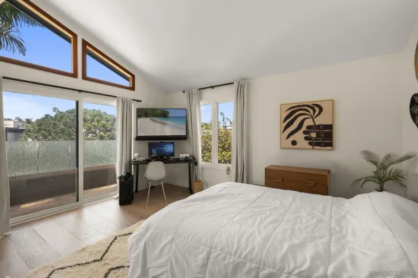 a bedroom with a large bed and a balcony view