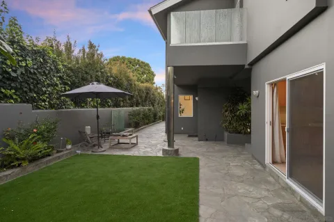 a view of a patio with chairs under an umbrella