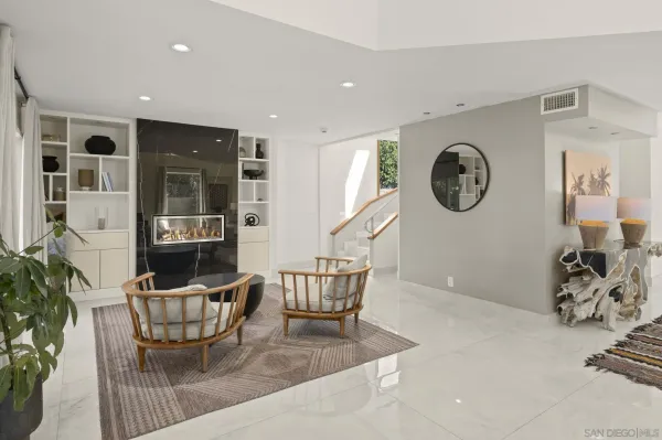 a living room with furniture a clock on wall and a window