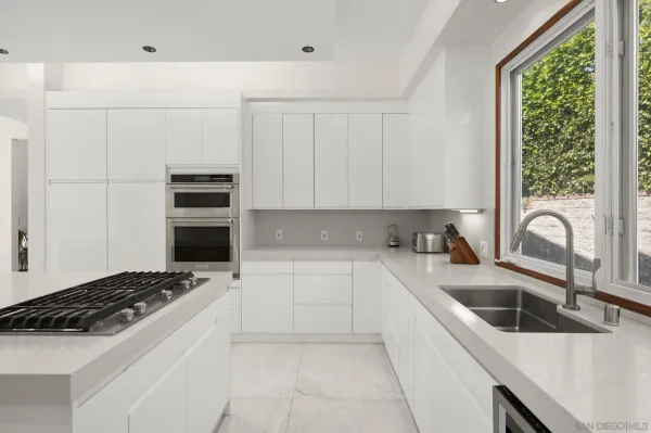 a kitchen with granite countertop a sink and a stove top oven
