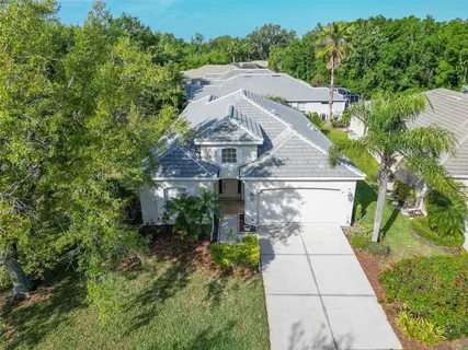 a aerial view of a house with a yard and large trees