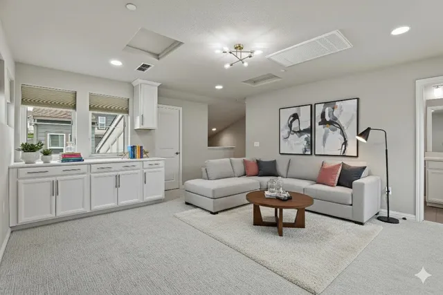 a living room with furniture and view of kitchen