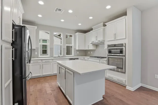 a kitchen with kitchen island a sink stove and refrigerator