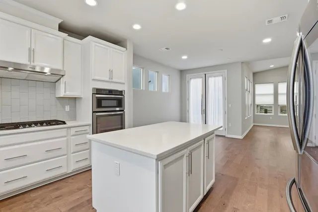 a kitchen with white cabinets and stainless steel appliances