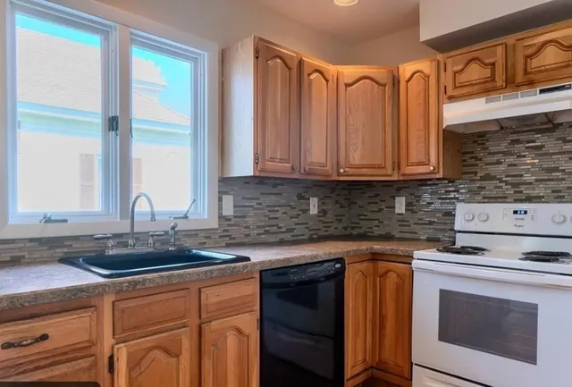 a kitchen with stainless steel appliances granite countertop a stove a sink and a microwave