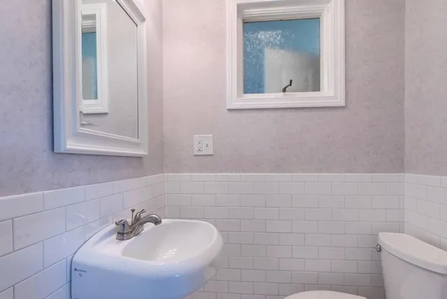 a bathroom with a sink mirror and toilet