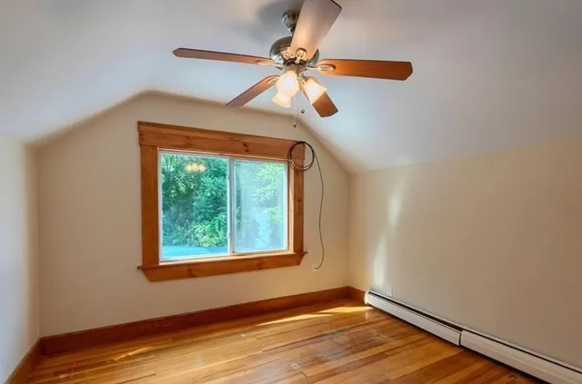 a view of an empty room with window and wooden floor