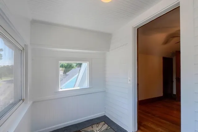 an empty room with wooden floor and a window