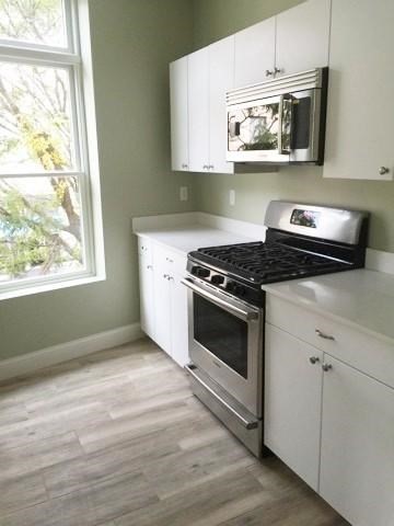10 Roxbury Street, Unit 8 Boston, MA 02119 - Photo 2 of 10 a kitchen with cabinets and window