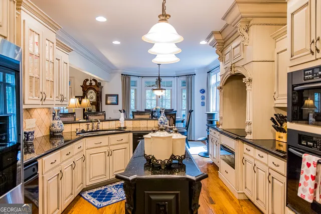 a kitchen with stainless steel appliances granite countertop a sink a refrigerator and a stove