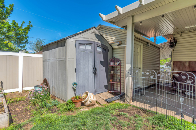127 West 300 North Springville, UT 84663 - Photo 23 of 24 Backyard featuring a shed, covered patio, and privacy fencing