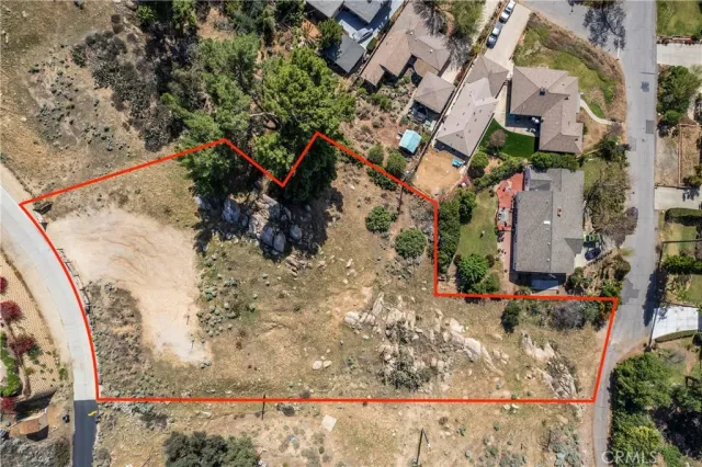 an aerial view of a house with a yard and large trees