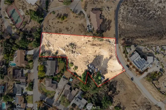 an aerial view of a house with a yard and large trees