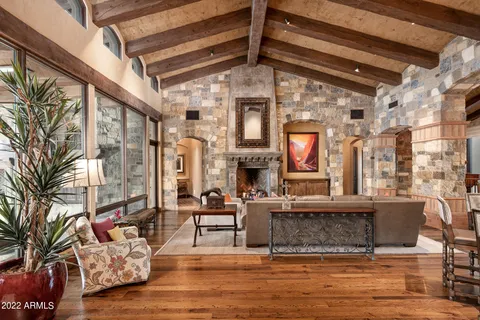 a living room with fireplace furniture and a large window