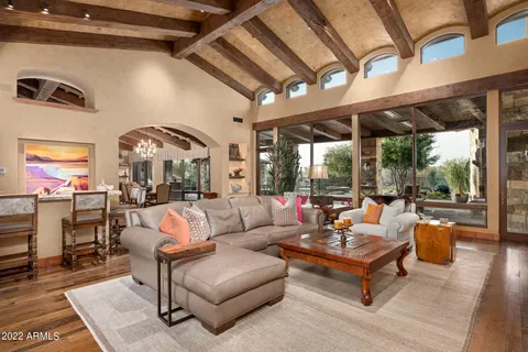 a living room with patio furniture and a large window