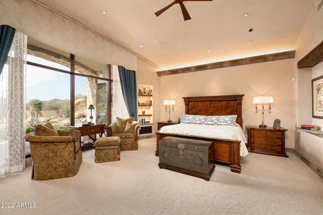 a bedroom with furniture and large windows