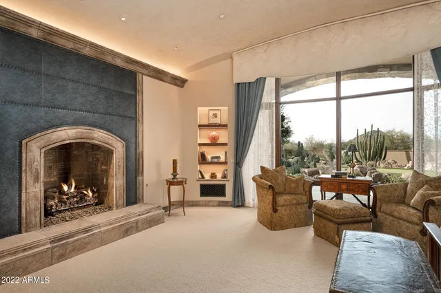 a living room with furniture a fireplace and a floor to ceiling window