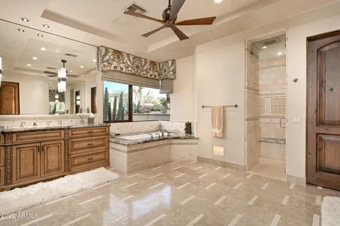a large white kitchen with a large window and stainless steel appliances