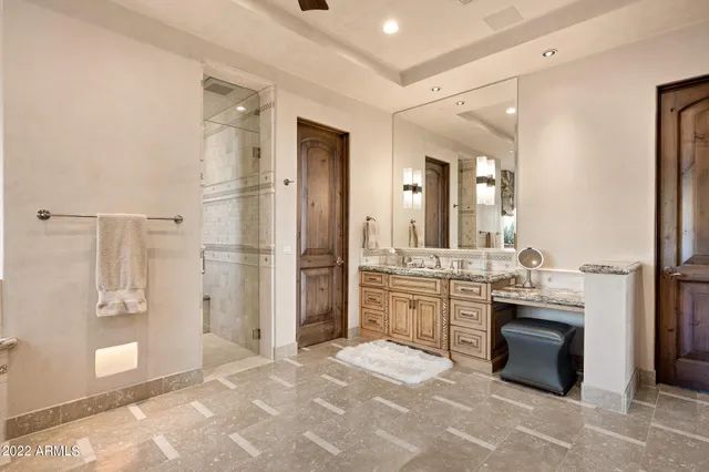 a spacious bathroom with a granite countertop sink mirror and shower